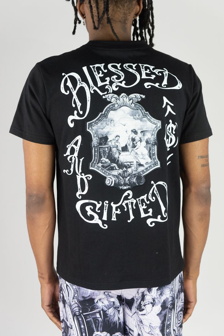 Person wearing a black t-shirt with 'Blessed and Gifted' design on a plain background