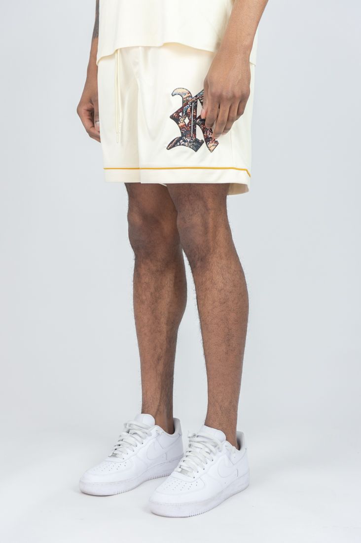 Person wearing a white skirt with a graphic design and white sneakers on a plain background