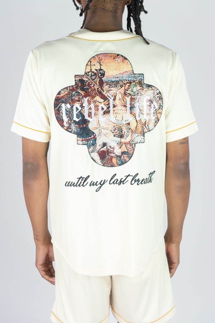 Person wearing a cream-colored t-shirt with a graphic design and text on a plain background