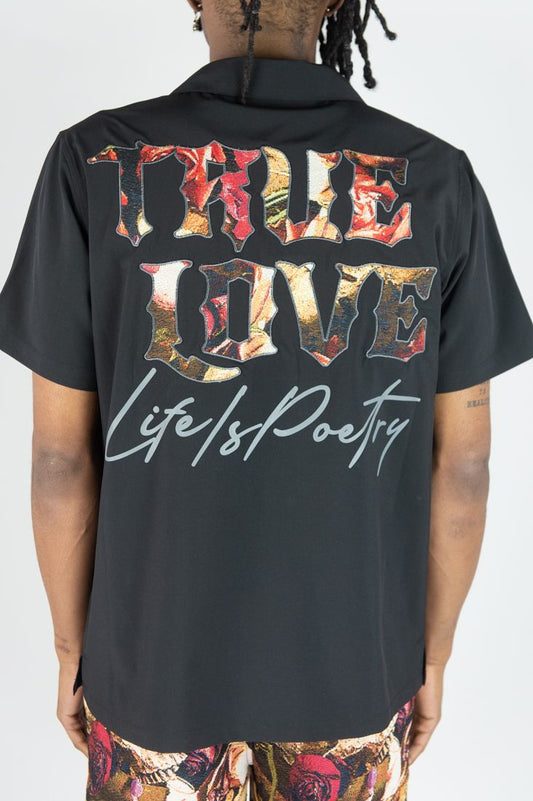 Black shirt with colorful text on the back, displayed on a person.