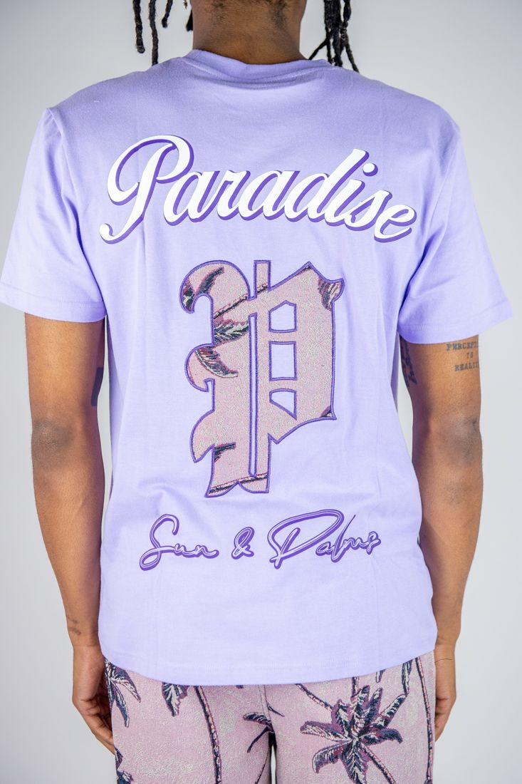 Person wearing a light purple t-shirt with 'Paradise' and decorative letter design.