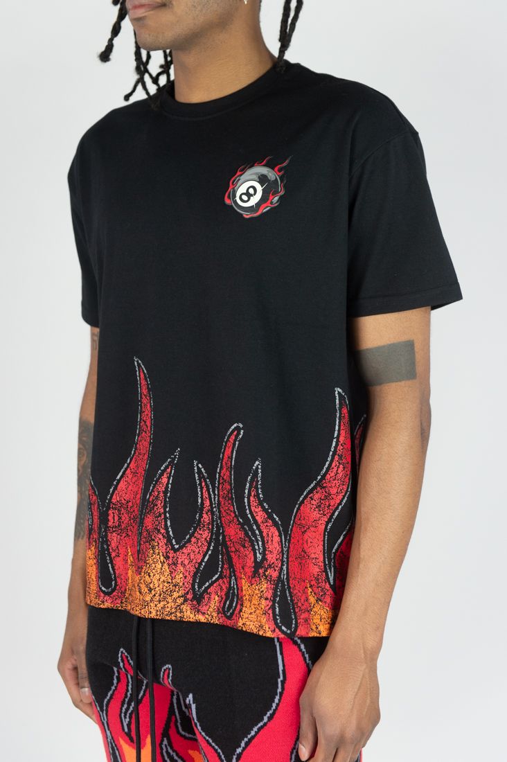 Person wearing a black t-shirt with flame design and logo on a white background