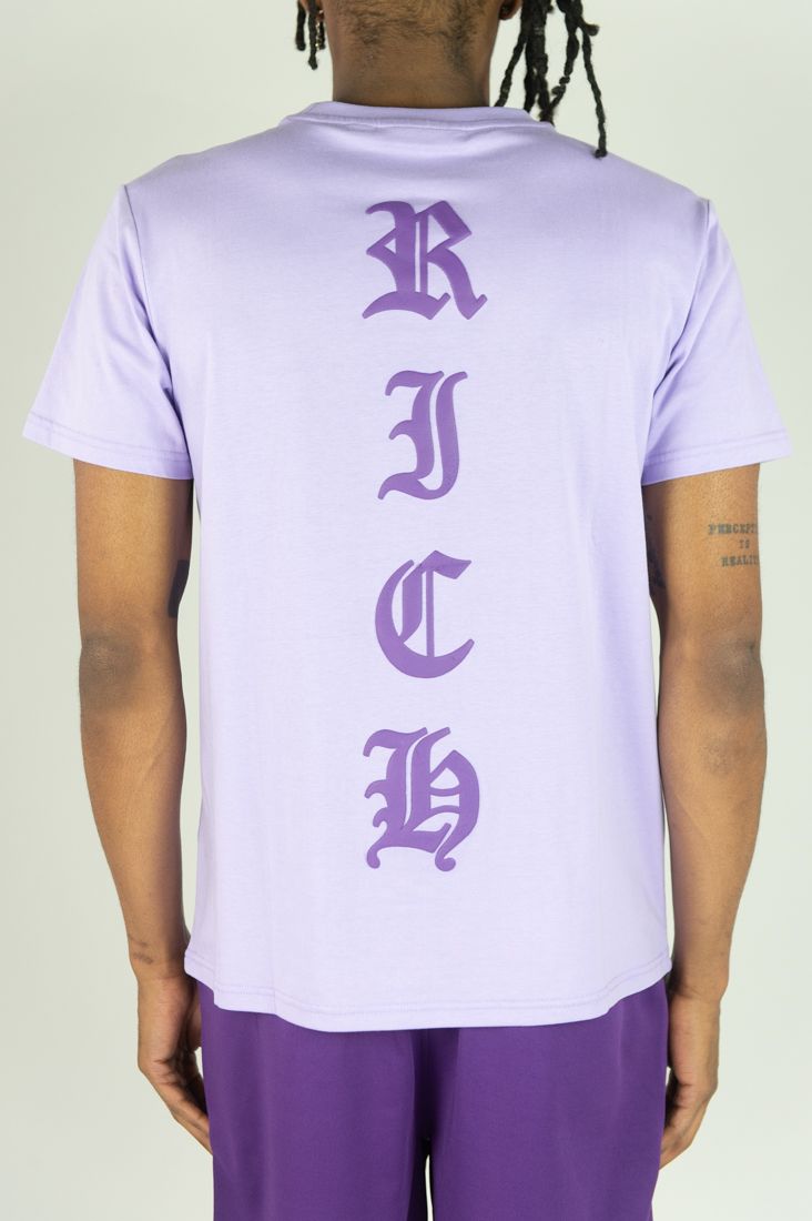 Person wearing a light purple t-shirt with 'RICHC' text on the back against a plain background