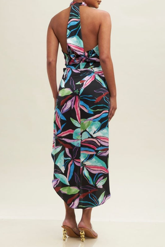 Woman wearing a colorful leaf-patterned dress on a beige background