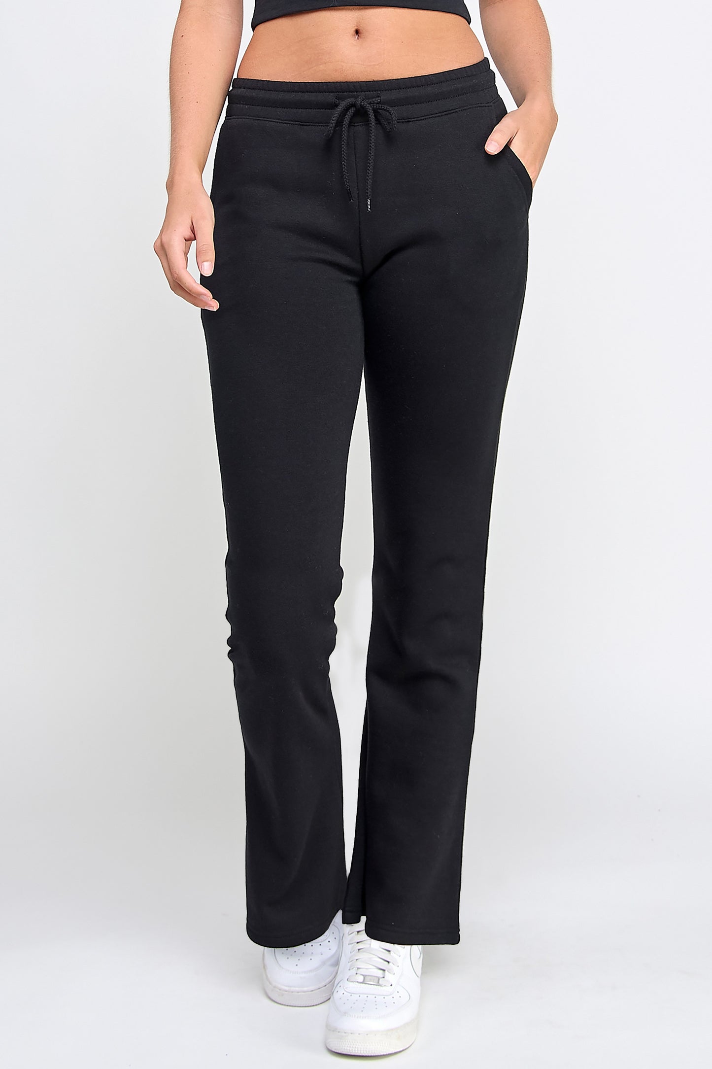 Black drawstring pants worn by a person on a white background