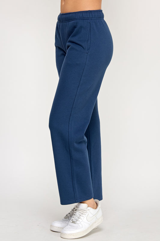 Navy blue sweatpants worn by a person on a white background