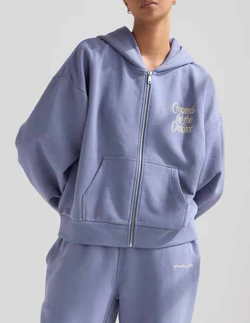 Person wearing a light blue tracksuit with a brand logo on a white background