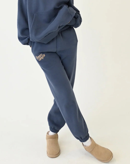 Woman wearing a blue tracksuit with beige boots on a white background.
