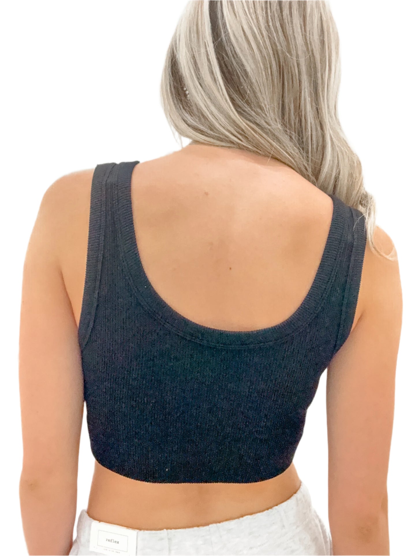 Person wearing a dark blue knit crop top against a white background