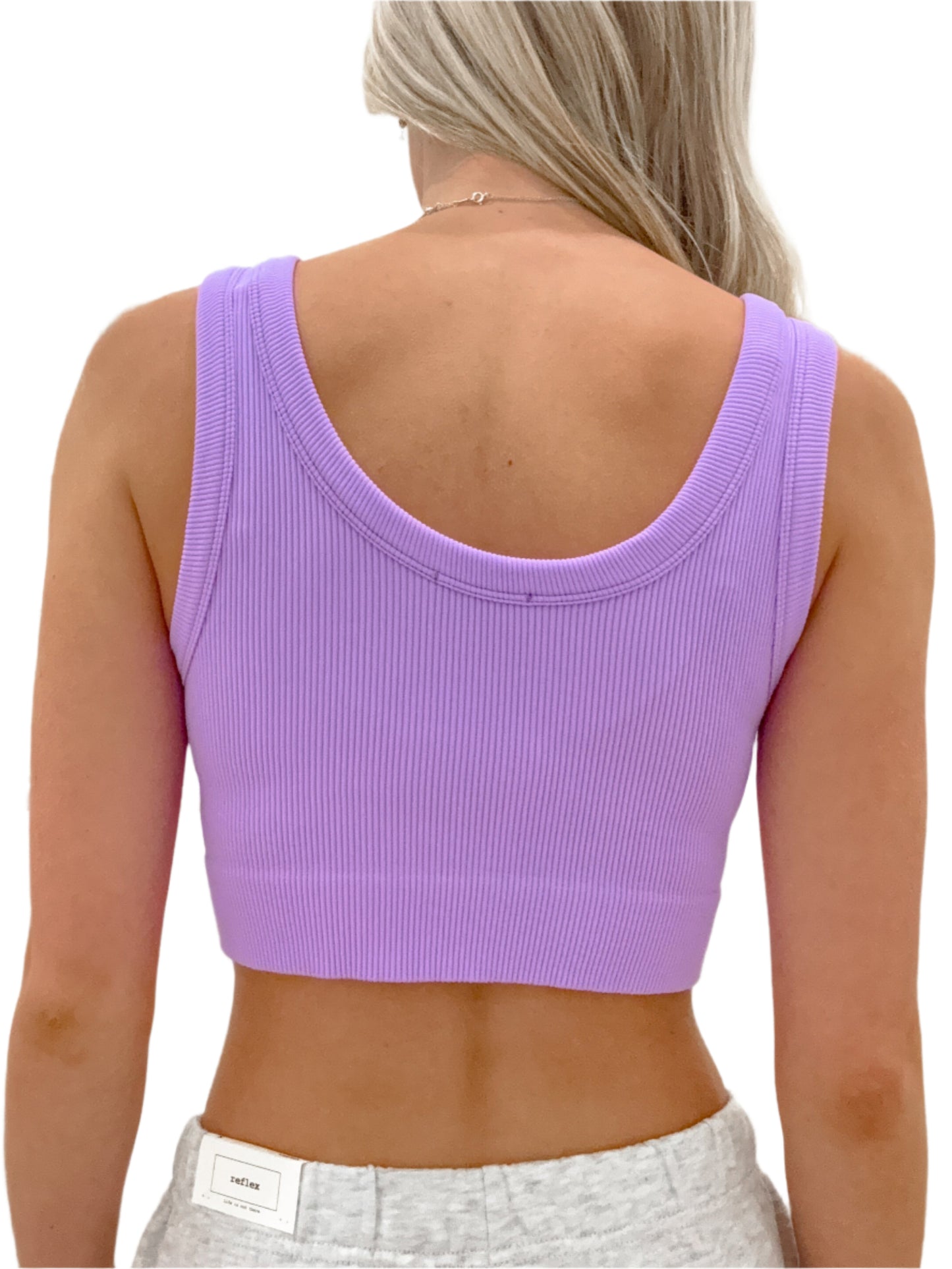 Person wearing a purple crop top with a white background