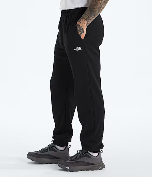Person wearing black sweatpants with a brand logo on a white background