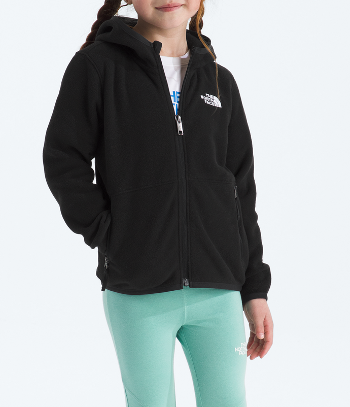 Young girl wearing a black hoodie and light green pants on a white background