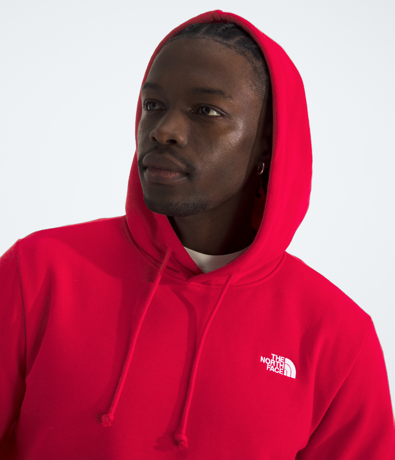 Person wearing a red hoodie with a brand logo on a white background