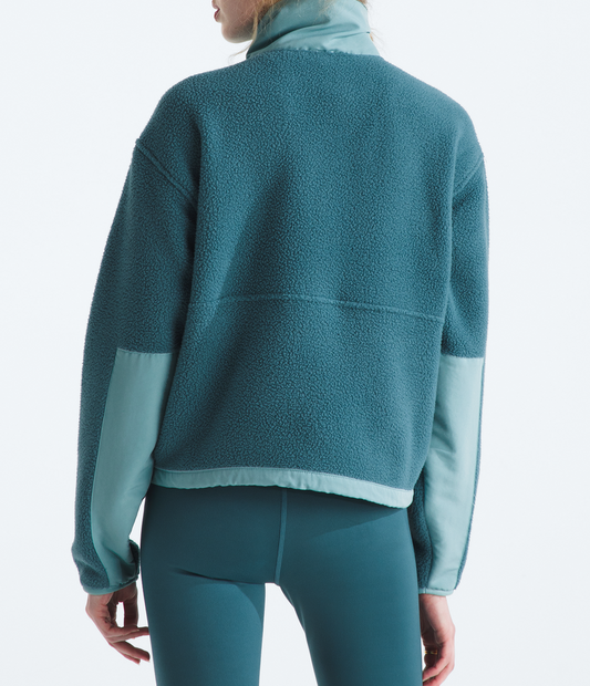 Person wearing a teal fleece jacket and pants with a matching beanie on a white background