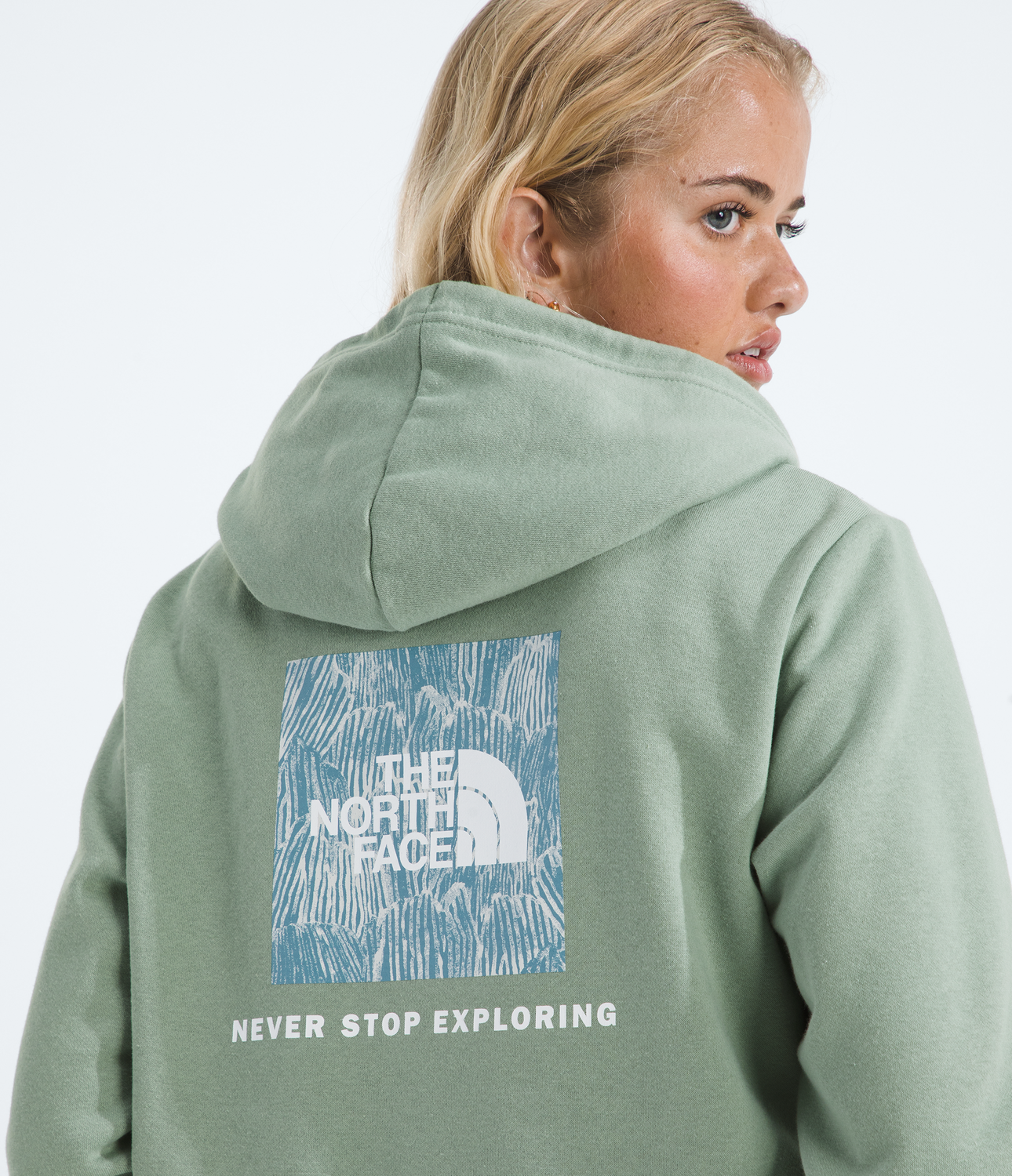 Person wearing a green hoodie with The North Face logo and text on the back