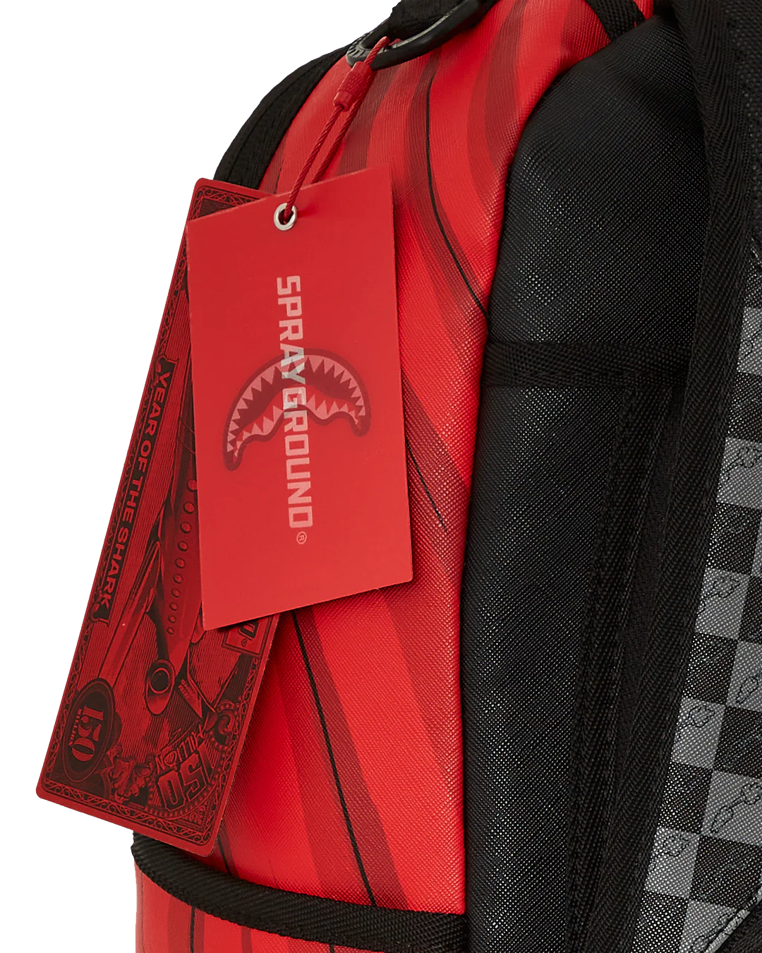 Red backpack with a visible Sprayground tag on a white background