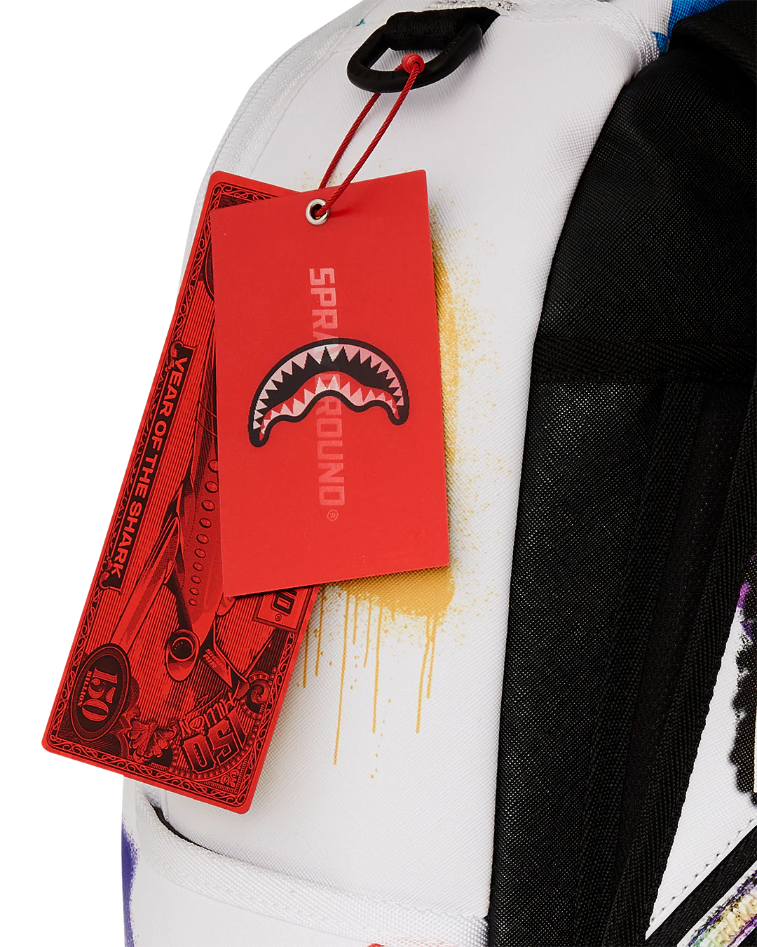 Red tag with a shark logo on a multicolored backpack