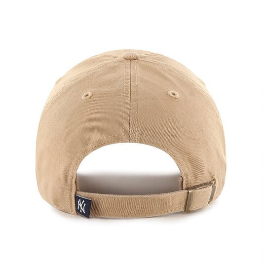 A front view of a beige baseball cap with a prominent navy blue "NY" logo embroidered on the front, and a small "47" logo on the side.