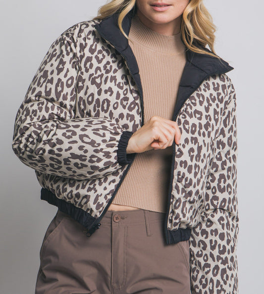 Woman wearing a leopard print jacket with a plain background