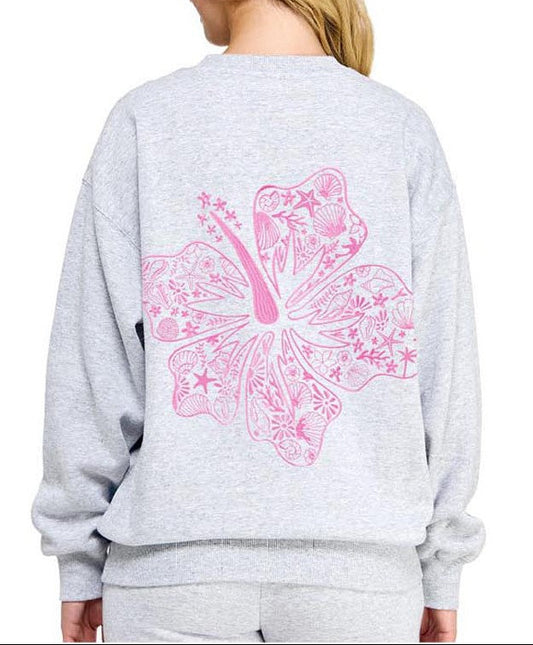 Gray sweatshirt with a pink butterfly design on the back, worn by a person.