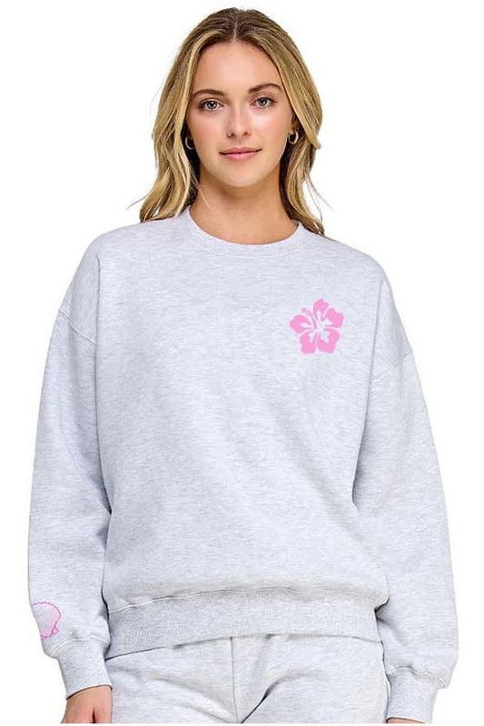 Person wearing a gray sweatshirt with a pink logo on a white background