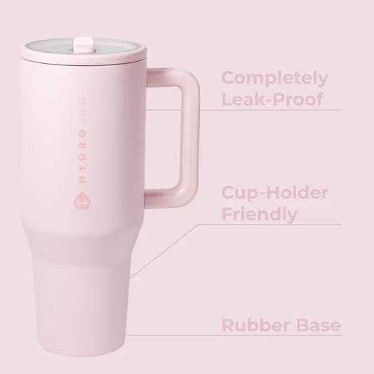 Hydrojug Pink mug with a lid on a light pink background, featuring text about its features.