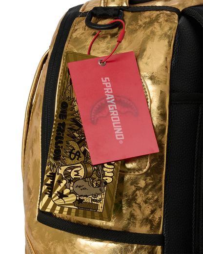 Gold metallic backpack with a red 'Sprayground' tag