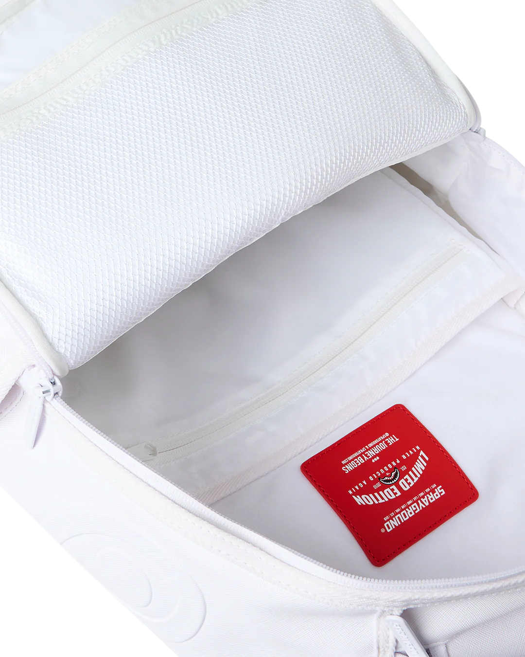 Close-up of an open white backpack showing the interior lining and a red interior brand patch that reads Limited Edition.