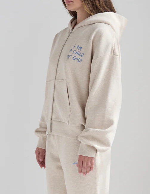 Person wearing a beige onesie with text on a plain background