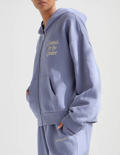 Person wearing a light blue hoodie and pants with text on a plain background