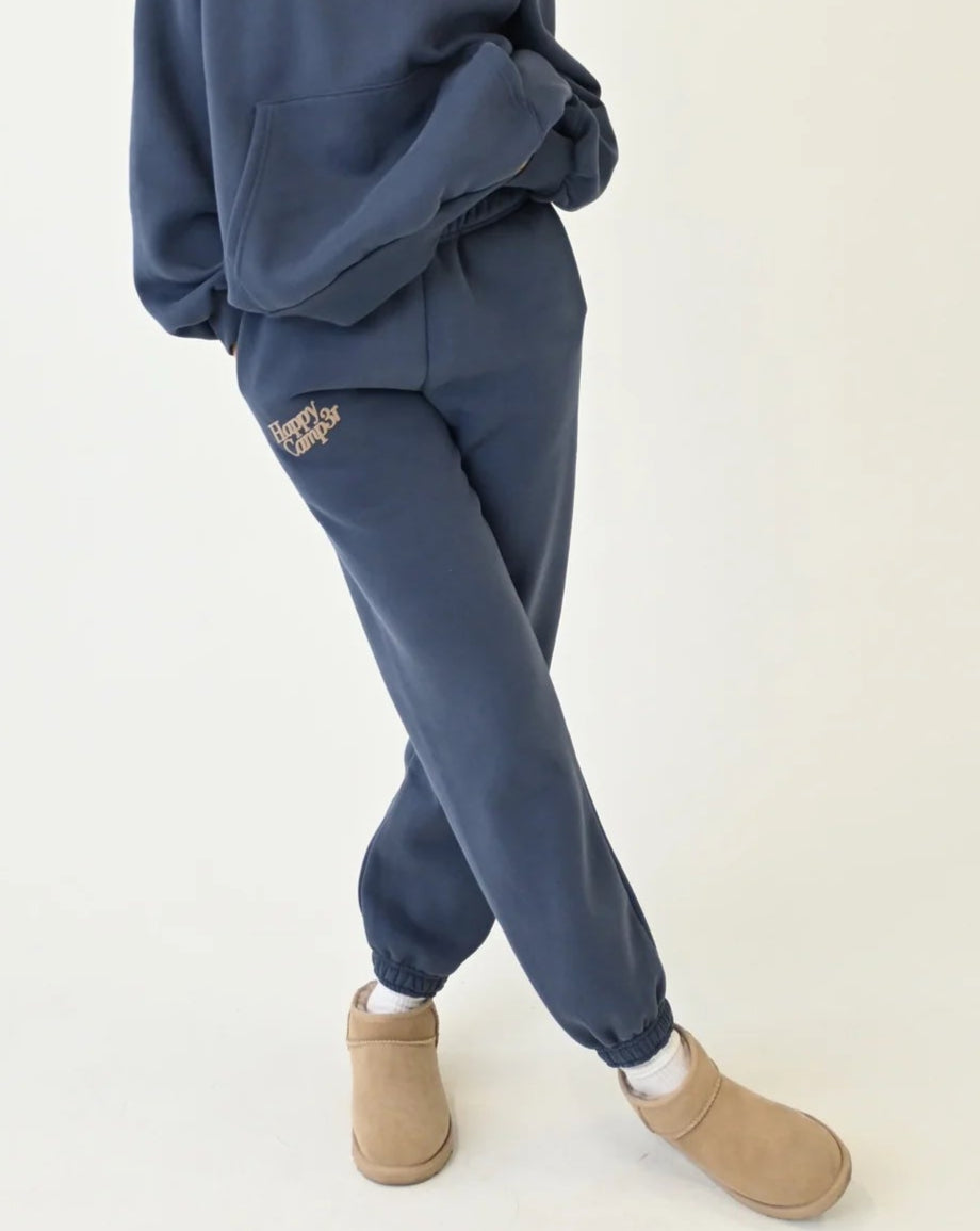 Woman wearing a blue tracksuit with beige boots on a white background.
