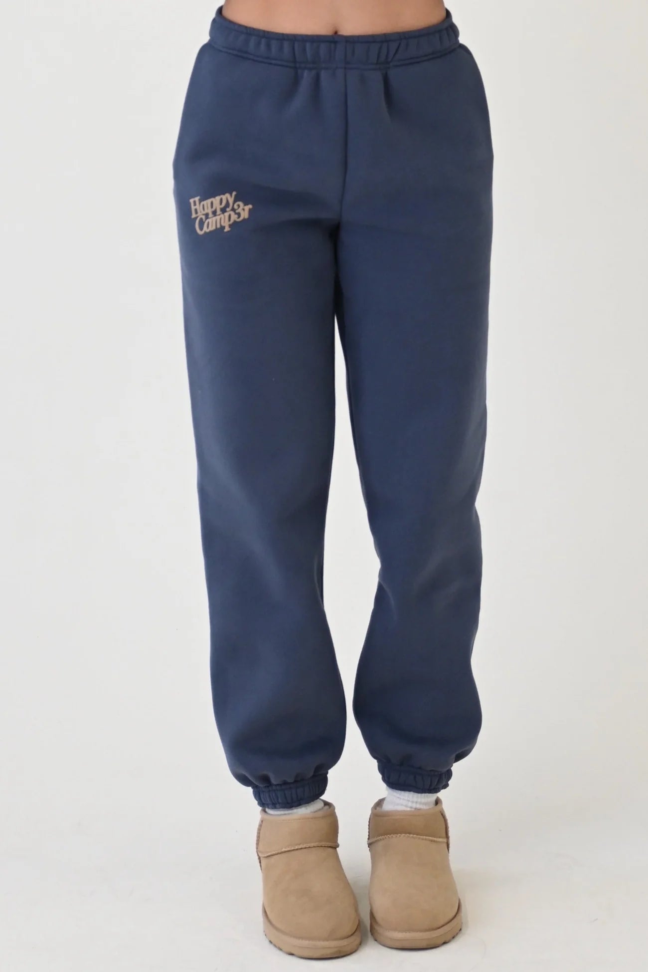 Navy sweatpants with a logo worn by a person on a white background