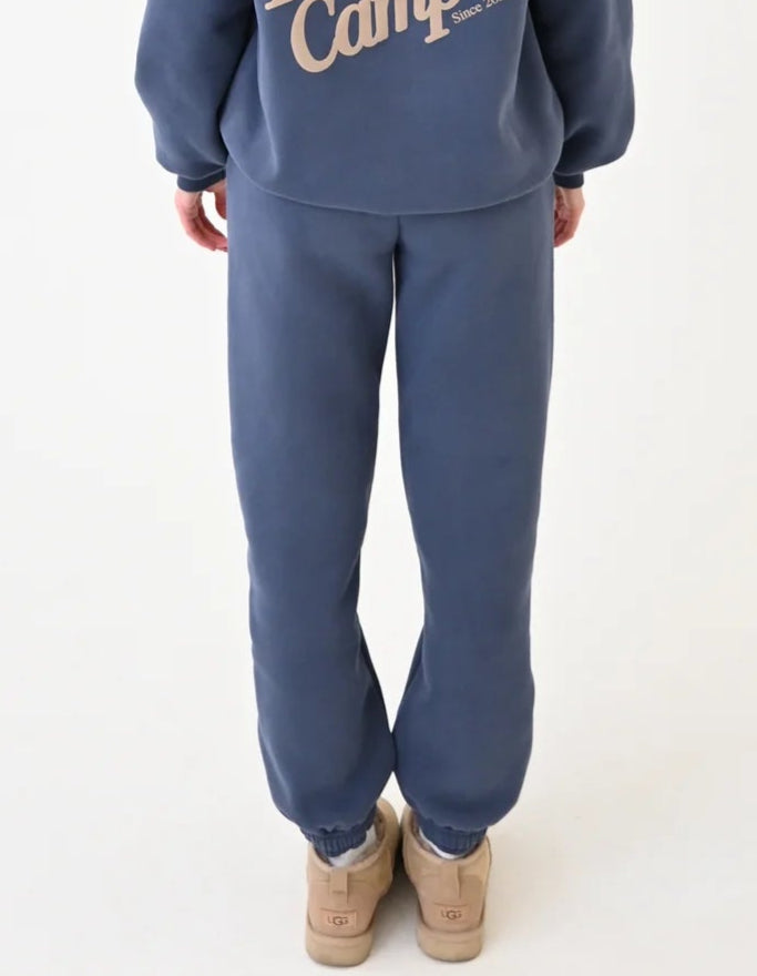 Person wearing a blue 'Happy Campers' hoodie and pants on a white background