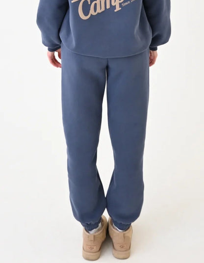 Person wearing a blue 'Happy Campers' hoodie and pants on a white background
