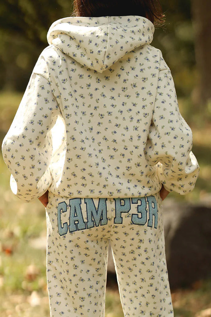 Person wearing a patterned hoodie and 'CAMP 3' pants in an outdoor setting