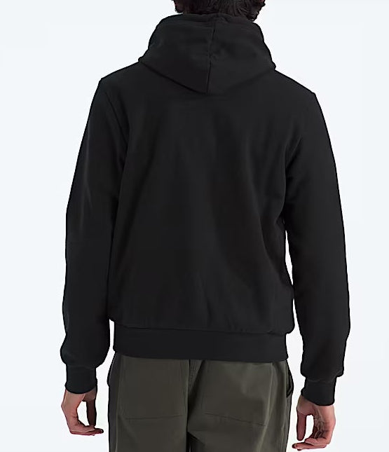 Person wearing a black hoodie and green pants on a white background