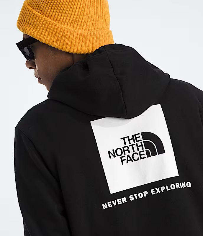 Person wearing a black hoodie with The North Face logo and 'Never Stop Exploring' text on a white background