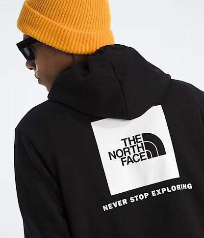 Person wearing a black hoodie with The North Face logo and 'Never Stop Exploring' text on a white background