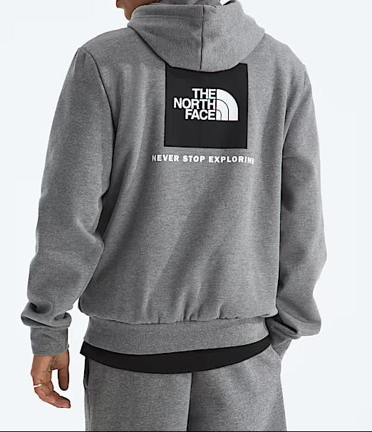 Person wearing a gray hoodie with The North Face logo on the back against a light gray background. 