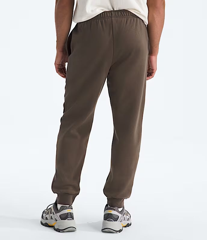 Brown sweatpants worn by a person on a white background