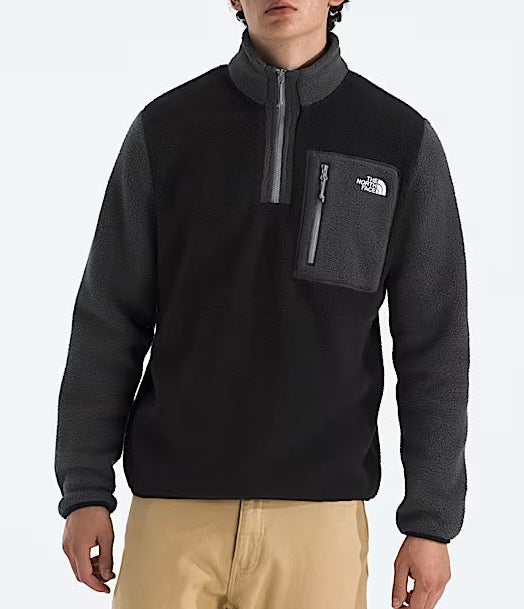 Person wearing a black and gray pullover with a visible brand logo on a white background