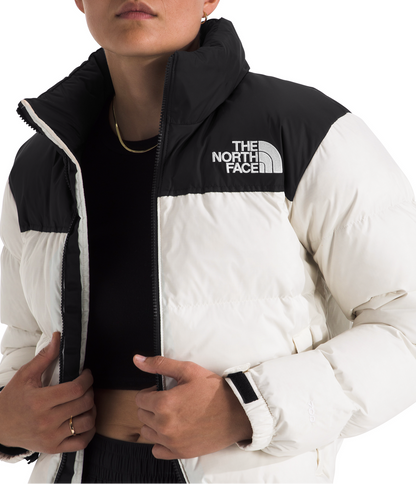 Person wearing a black and white The North Face jacket on a white background