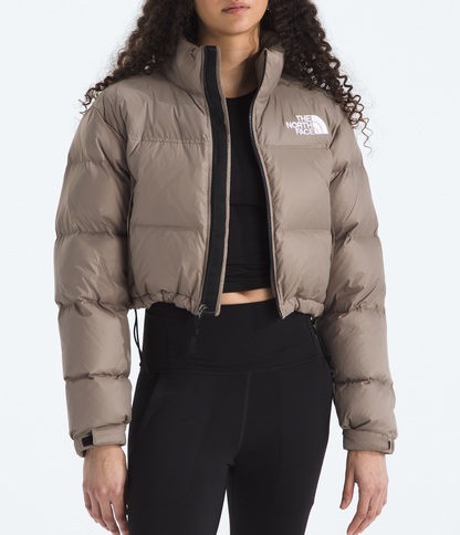 Woman wearing a beige puffer jacket with a brand logo on a white background 