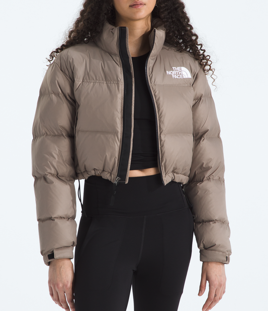 Woman wearing a beige puffer jacket with a brand logo on a white background 