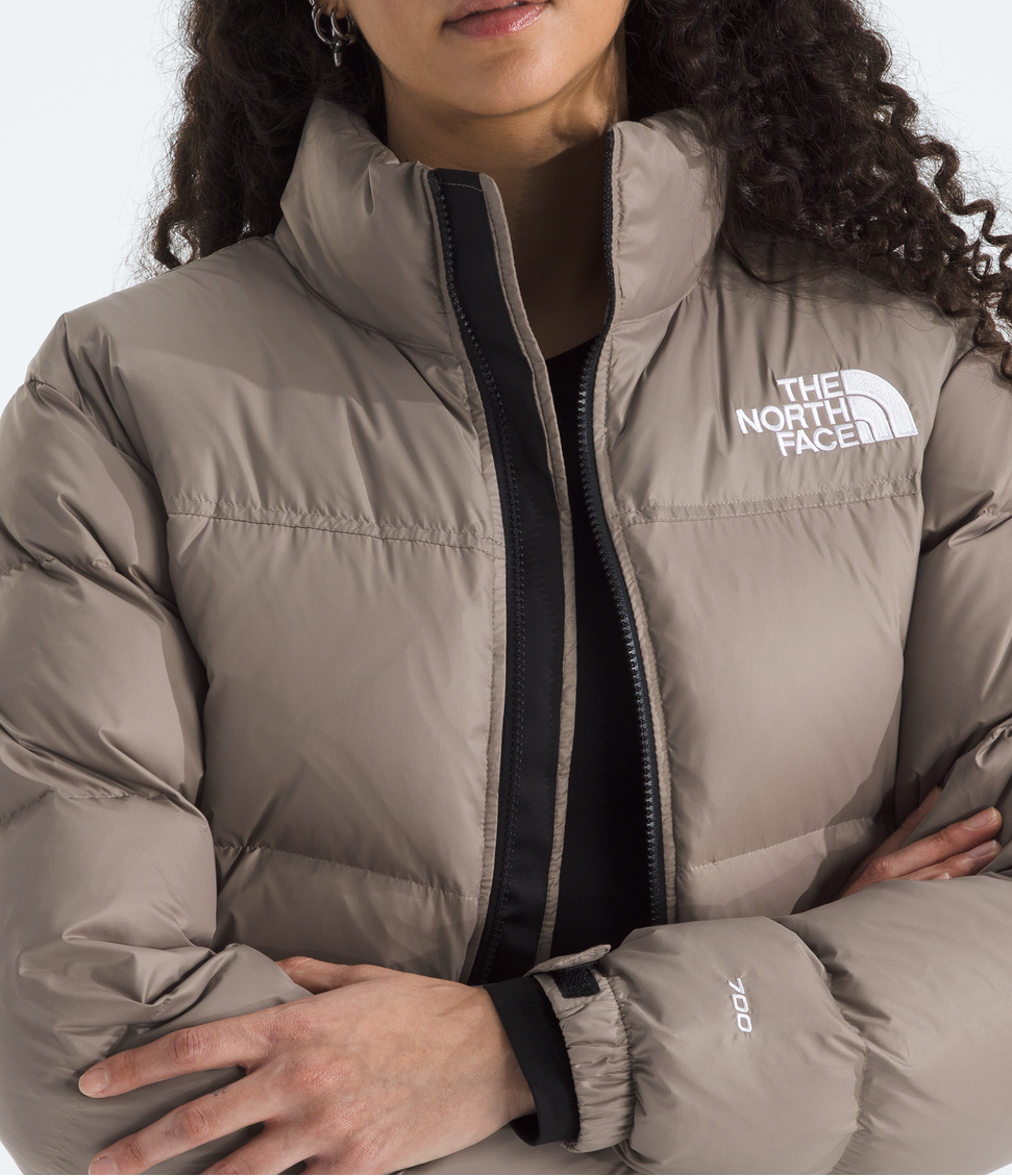 Woman wearing a The North Face puffer jacket on a white background
