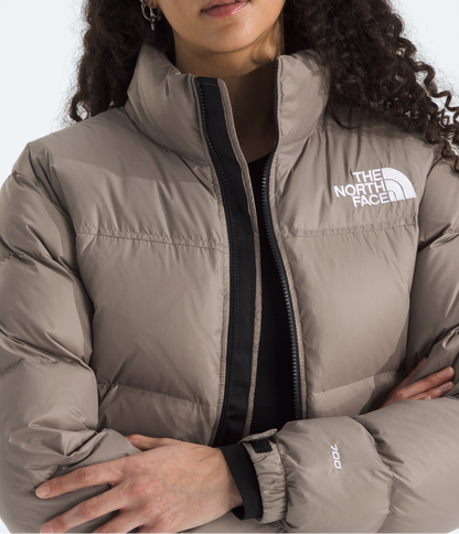 Woman wearing a The North Face puffer jacket on a white background