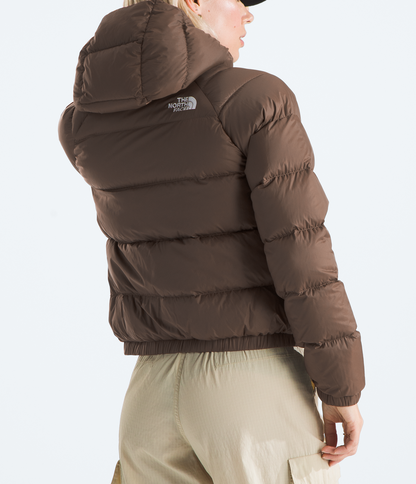Person wearing a brown puffer jacket with a visible brand logo on a white background