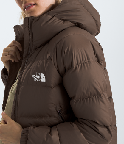 Person wearing a brown The North Face jacket and cap on a white background 