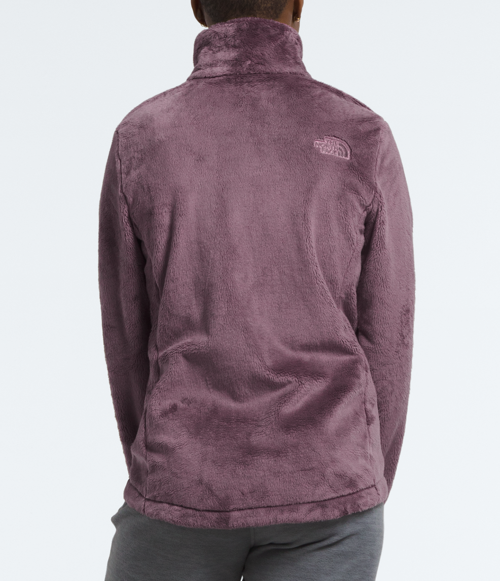 Person wearing a purple jacket with a brand logo on the back against a white background