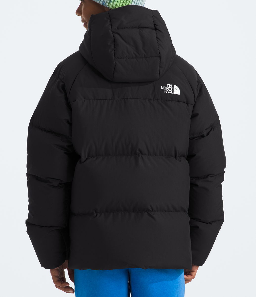 Person wearing a black puffer jacket with The North Face logo on a light gray background